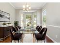 Formal dining room with wainscoting, large windows, chandelier, and seating for six at 2409 Valley Haven Dr, Raleigh, NC 27603