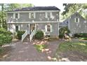 Two-story home boasts gray siding, white shutters, and a brick walkway framed by mature trees and lush lawn at 2708 Coleberry Trl, Rocky Mount, NC 27804