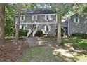 Charming two-story home featuring gray siding, white shutters, and a brick walkway amidst mature trees at 2708 Coleberry Trl, Rocky Mount, NC 27804