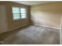 Cozy bedroom with neutral carpeting, a large window, and ample natural light at 2915 Ross Rd, Durham, NC 27703