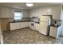Traditional kitchen featuring white cabinets, laminate countertops, and updated appliances at 2915 Ross Rd, Durham, NC 27703