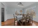 Elegant dining room with wood floors, wainscoting, and a stylish chandelier at 304 Indigo Pl, Garner, NC 27529