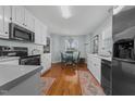 Efficient kitchen boasts white cabinets, stainless steel appliances, and a cozy breakfast nook at 304 Indigo Pl, Garner, NC 27529