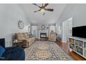 Bright living room features a ceiling fan, fireplace, and beautiful hardwood floors at 304 Indigo Pl, Garner, NC 27529