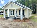 Well-maintained home featuring a classic design, front porch, and fresh landscaping in a natural setting at 307 N Church St, Kenly, NC 27542