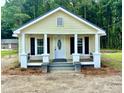 Inviting home exterior featuring a cozy front porch with black railings and manicured landscaping at 307 N Church St, Kenly, NC 27542