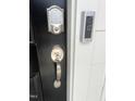 A close up of a smart lock on the black front door with a Ring doorbell at 3105 White Blossom Ct, Raleigh, NC 27610