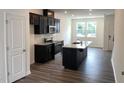 A modern kitchen with stainless steel appliances, an island and dark cabinetry at 3105 White Blossom Ct, Raleigh, NC 27610