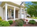 Inviting front porch with rocking chairs, beautiful landscaping, and charming details at 33 Village Walk Dr, Chapel Hill, NC 27517