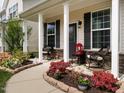 Welcoming front porch with stone accents and colorful flower beds bordering the walkway at 4179 Dunkirk Dr, Burlington, NC 27215