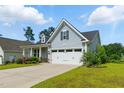 Charming single-story home with light blue siding, a two-car garage and manicured landscaping on a sunny day at 45 Glen Bend Ct, Spring Lake, NC 28390
