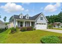 Inviting one-story home with light blue siding, dormer windows, and a two-car garage under a bright blue sky at 45 Glen Bend Ct, Spring Lake, NC 28390