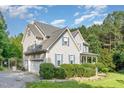 Well-maintained two-story home with attached garage, blue shutters, and mature trees at 457 Poplar Forest Ln, Pittsboro, NC 27312