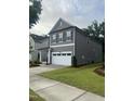 Two-story home with neutral siding, a two-car garage, manicured lawn, and inviting curb appeal at 4940 Enlightenment Rd, Raleigh, NC 27616