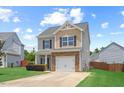 Charming two-story home with a manicured lawn, stone accents, and an attached one car garage at 504 Gumview Cir, Fuquay Varina, NC 27526