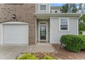A close-up view of the front entrance of the townhome with a glass door and attached garage at 515 Historic Dr, Hillsborough, NC 27278