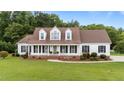 Charming two-story home featuring a large front yard and inviting front porch with rocking chairs at 541 Mallie Pearce Rd, Zebulon, NC 27597