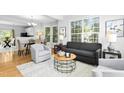 Bright living room featuring hardwood floors, large windows, and stylish furniture at 5545 Crabtree Park Ct, Raleigh, NC 27612
