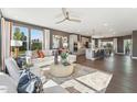 Open-concept living room with modern furniture, hardwood floors and lots of natural light, seamless to kitchen at 600 Hedrick Ridge Road # 310 209, Cary, NC 27519