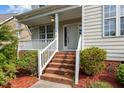 Inviting front porch with brick steps, white railings, and lush landscaping providing curb appeal at 603 Everglades Dr, Mebane, NC 27302