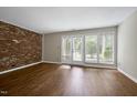 Bright living room with laminate floors and a brick accent wall at 606 Oak Tree Dr, Chapel Hill, NC 27517