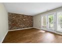 Living room featuring a brick accent wall and patio access at 606 Oak Tree Dr, Chapel Hill, NC 27517