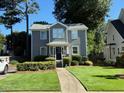 Charming two-story home with gray siding, manicured lawn, and inviting curb appeal at 627 New Road, Raleigh, NC 27608