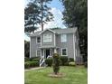 Lovely two-story house featuring gray siding, a manicured lawn, and mature trees at 627 New Road, Raleigh, NC 27608