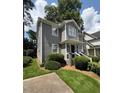 Well-maintained two-story home with gray siding, green lawn, and lush landscaping at 627 New Road, Raleigh, NC 27608