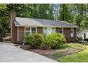 Quaint brick home featuring a charming entryway and mature landscaping, set back from the road at 7916 Foxwood Dr, Raleigh, NC 27615
