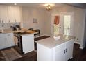 Bright kitchen featuring white cabinets, quartz countertops and a large island with a breakfast bar at 80 Stoneridge Rd, Durham, NC 27705