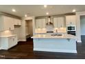 Bright kitchen featuring white cabinets, stainless steel appliances, and a spacious center island with sink at 820 Emerald Bay Cir # 762, Raleigh, NC 27610