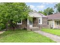 Quaint stone home featuring a welcoming porch and lush green lawn with a mature tree at 919 Chester St, Durham, NC 27701