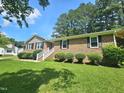 Well-kept brick home showcasing a lush green lawn and manicured landscaping for a welcoming aesthetic at 112 Saddletree Rd, Oxford, NC 27565