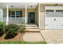 Close-up of the front door with decorative glass, stone steps, and manicured flower beds at 11612 Leesville Rd, Raleigh, NC 27613