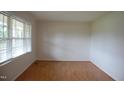 Bright, empty room with wood floors and lots of natural light from the windows at 1418 Sherron Rd, Durham, NC 27703