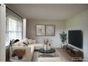 Bright living room with neutral palette, contemporary furnishings, and ample natural light at 1418 Sherron Rd, Durham, NC 27703