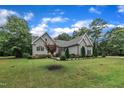 Well-maintained home showcases a beautifully landscaped front yard, gray siding, and mature trees at 152 Abundant Ave, Angier, NC 27501