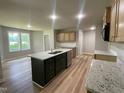 Modern kitchen features a large island with granite countertops and stainless steel appliances at 168 Oakfield Trace Dr, Four Oaks, NC 27524