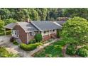 Aerial view of a traditional home with a brick exterior, mature trees, and landscaped yard at 211 Forestview Dr, Elon, NC 27244