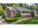 Beautiful home showcasing brick siding, well-manicured landscaping, and a covered front porch at 211 Forestview Dr, Elon, NC 27244