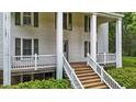 Close-up view of the front entrance, showcasing wooden steps, white railings, and green shutters at 4053 Friendship Patterson Mill Road, Burlington, NC 27215