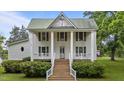 Charming two-story house with white siding and green shutters, featuring a covered front porch at 4053 Friendship Patterson Mill Road, Burlington, NC 27215