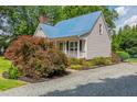 Charming single-Gathering home with a blue metal roof and well-manicured landscaping at 4067 Williams Mill Rd, Burlington, NC 27215