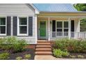A charming front porch with brick steps and green door leads to the main entrance of the home at 4067 Williams Mill Rd, Burlington, NC 27215