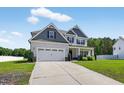 Inviting two-story home featuring a two-car garage and lush green lawn at 414 Fallingbrook Dr, Kenly, NC 27542