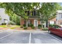 Inviting townhome featuring a well-maintained lawn, brick facade, and convenient parking in front at 4406 Still Pines Dr, Raleigh, NC 27613