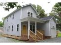 Two-story home featuring a welcoming front porch with steps and an attached garage at 4511 Denfield St, Durham, NC 27704
