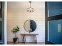 Elegant foyer with shiplap walls, stylish round mirror and modern rustic table adorned with flowers and greenery at 46 Lakes Edge Ln, Pittsboro, NC 27312