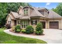 Side exterior view of a well maintained home with attached two car garage and landscaped walkway at 512 Belmont Cir, Wake Forest, NC 27587